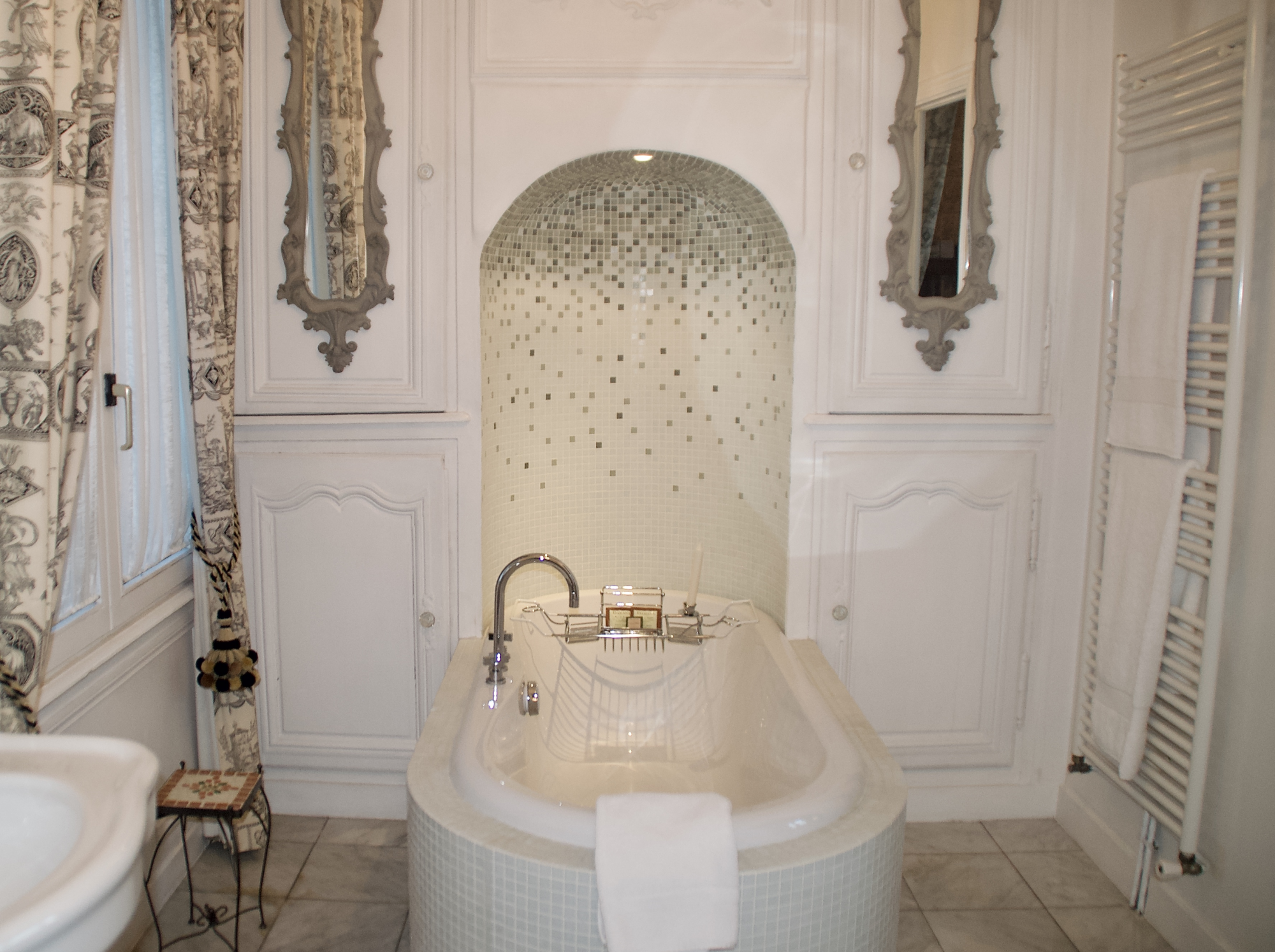 The mosaic and marble tiled bathroom in the Empire suite has a soaking tub and separate walk in shower.