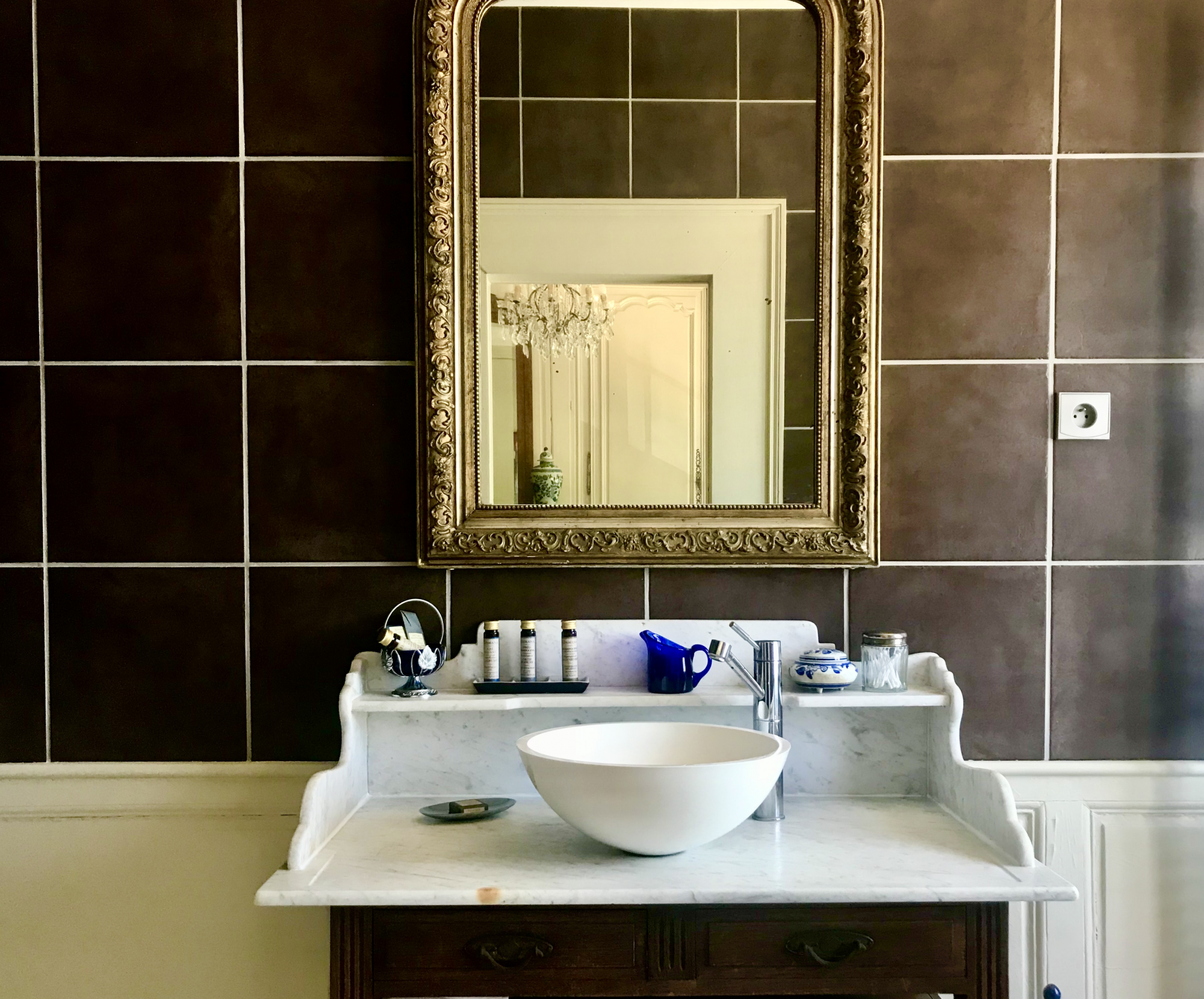 The private washroom in the Deluxe Double suite has an antique washbasin and a combined bath and shower.  Decorated with deep brown and cobalt blue tones the bathroom includes vegan amenities from the Damana hotel line, a hair dryer and thick Egyptian cotton towels.